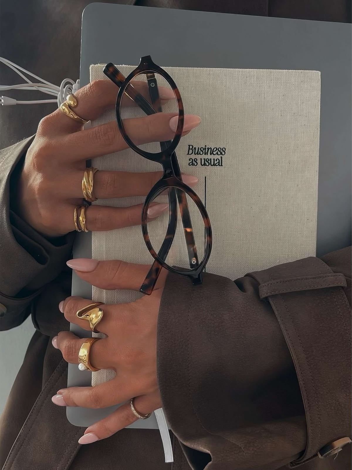 Hands holding glasses over a notebook and laptop